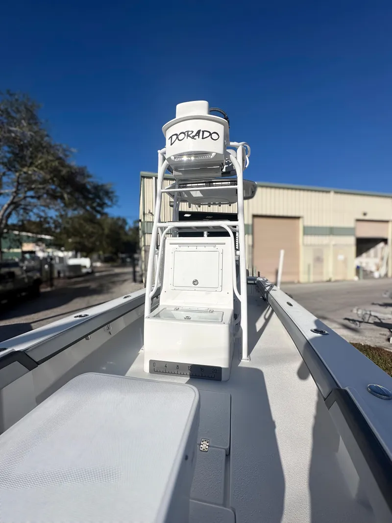 Slide: The Image of 2021 Dorado 25 FD boat, white exterior, docked near industrial building under clear blue sky. - 12