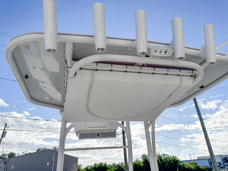 Slide: The Image of Dorado 25 FD 2021 boat canopy with rod holders against blue sky. - 18