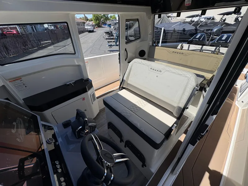 Slide: The Image of Interior of 2025 Navan C30 boat with seating and control area, docked outdoors. - 17