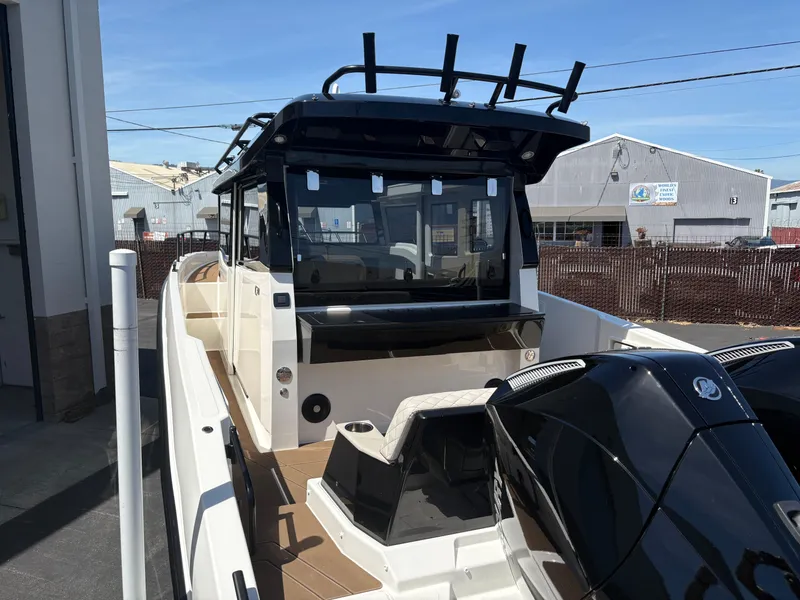 Slide: The Image of Navan C30 2025 boat with dual engines, docked near industrial buildings under clear sky. - 7
