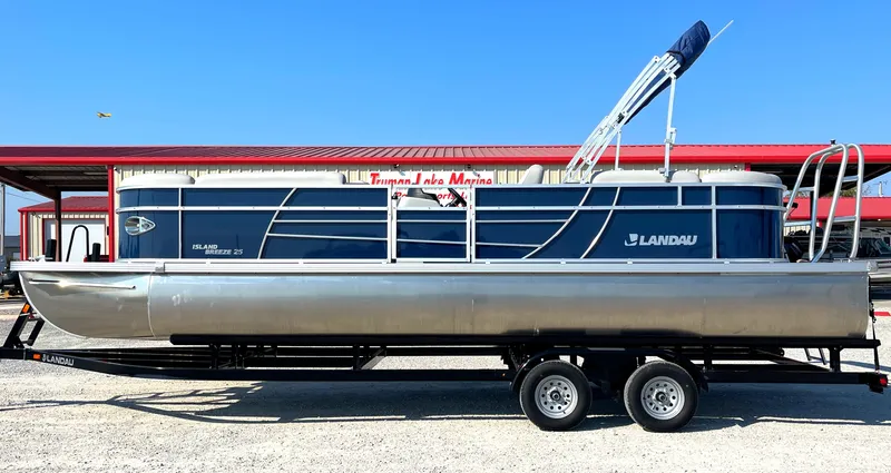 The Image of 2025 Landau Island Breeze 25 pontoon boat with 225HP Suzuki engine on trailer. - 1