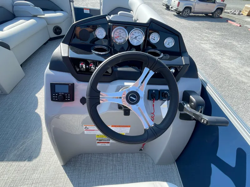 Slide: The Image of 2025 Landau Island Breeze 25 boat dashboard with steering wheel and gauges. - 13