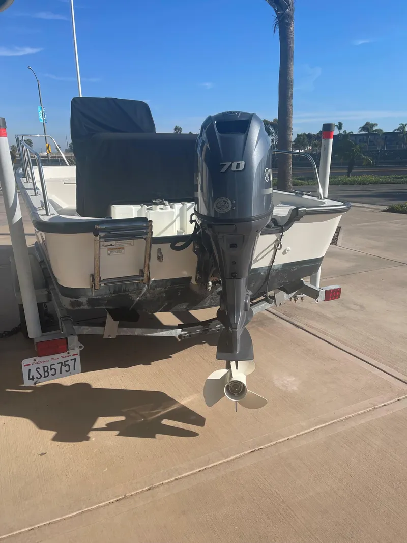Slide: The Image of 2017 Boston Whaler 150 Montauk boat with outboard motor on trailer. - 5