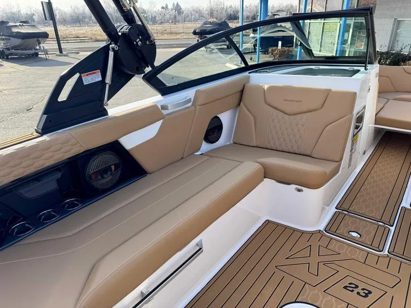 Slide: The Image of 2025 MasterCraft XT23 boat interior with tan seating and modern design. - 10