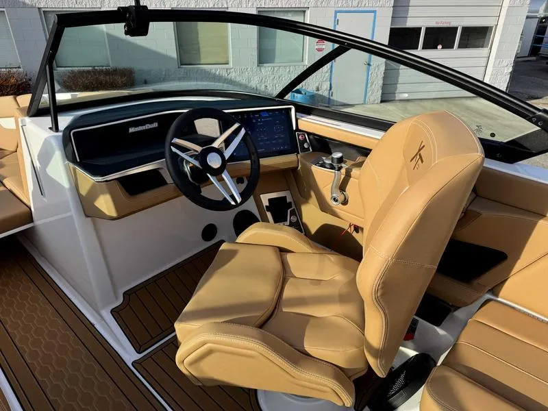Slide: The Image of 2025 MasterCraft XT23 boat interior with tan leather seats and modern dashboard. - 11