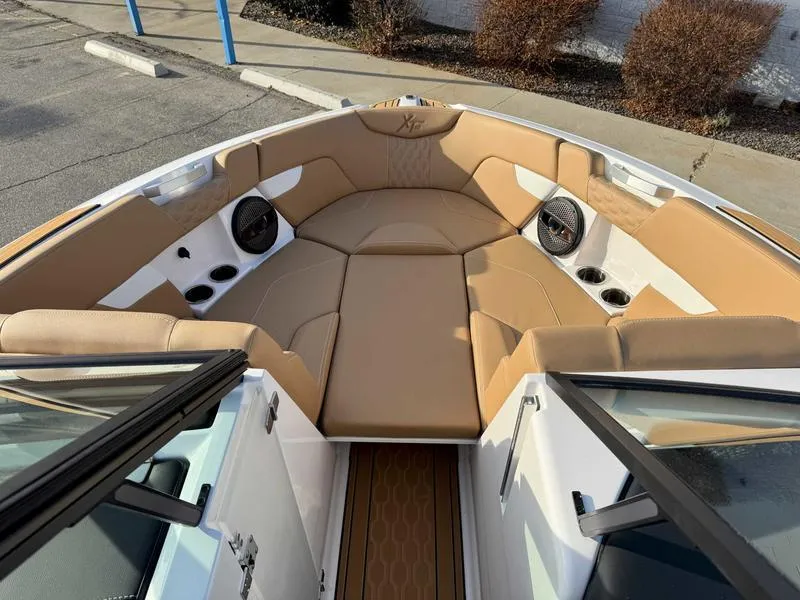 Slide: The Image of 2025 MasterCraft XT23 boat interior with tan seating and built-in speakers. - 13