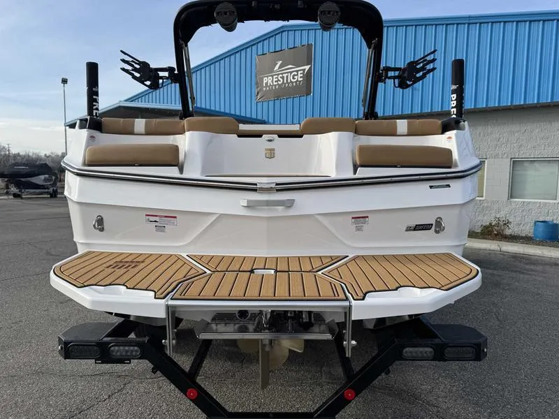 Slide: The Image of 2025 MasterCraft XT23 boat with teak deck, parked at Prestige dealership. - 6