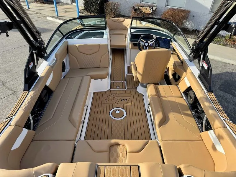 Slide: The Image of 2025 MasterCraft XT23 boat interior with tan seating and sleek design. - 9