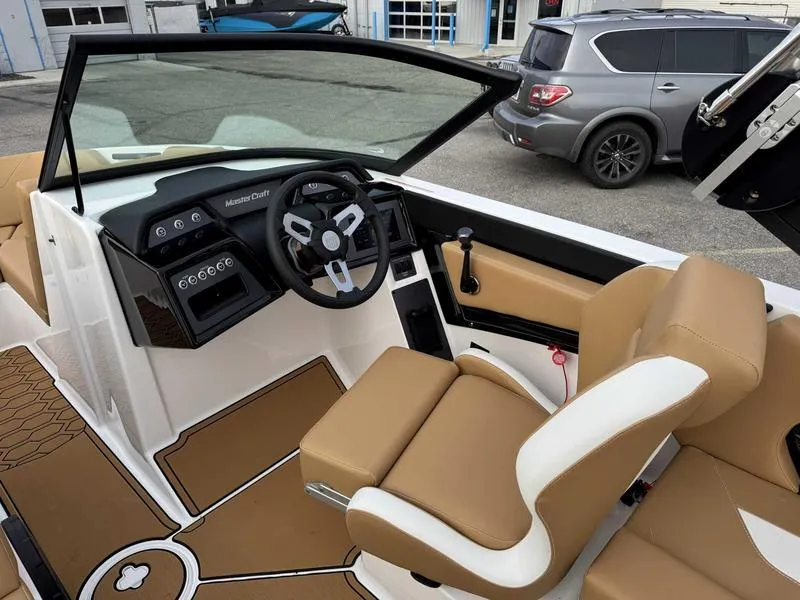 Slide: The Image of 2025 MasterCraft NXT20 boat interior with tan seats and modern dashboard. - 11