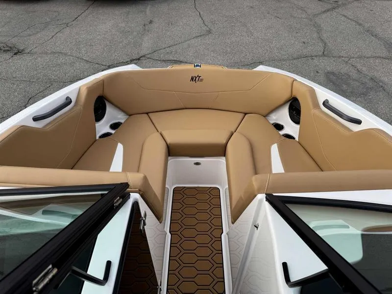 Slide: The Image of 2025 MasterCraft NXT20 boat interior with tan seating and hexagonal flooring. - 14