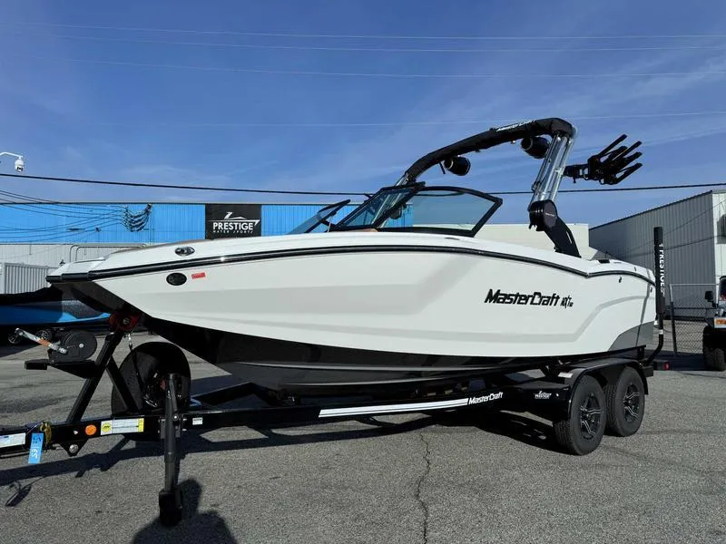 Slide: The Image of 2025 MasterCraft NXT20 boat on trailer, parked outdoors under clear sky. - 3