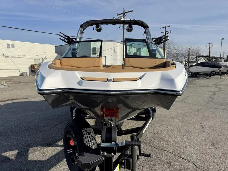 Slide: The Image of 2025 MasterCraft NXT20 boat on trailer, front view, parked outdoors. - 4