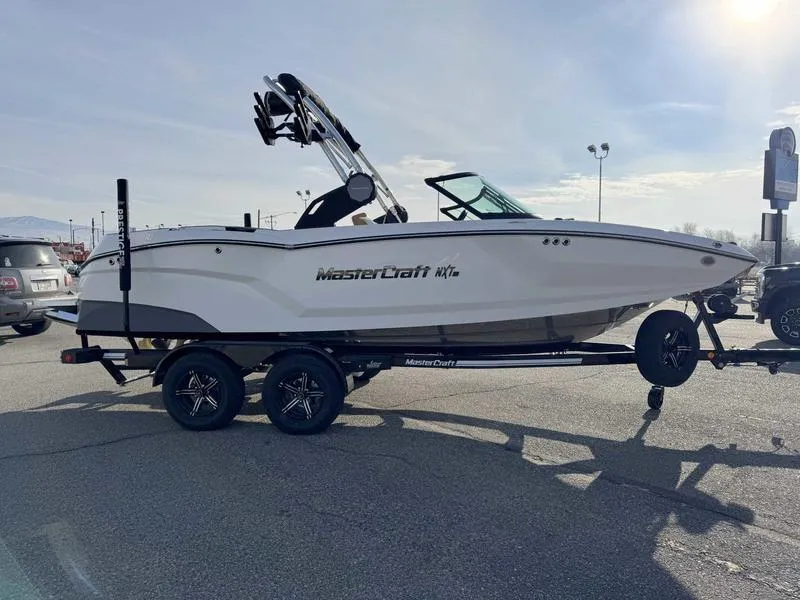 Slide: The Image of 2025 MasterCraft NXT20 boat on trailer in parking lot, side view. - 5