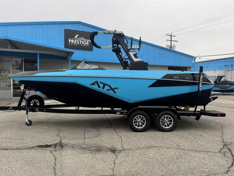 Slide: The Image of 2025 ATX Surf Boats 22 Type-S in blue, parked outside Prestige dealership. - 1