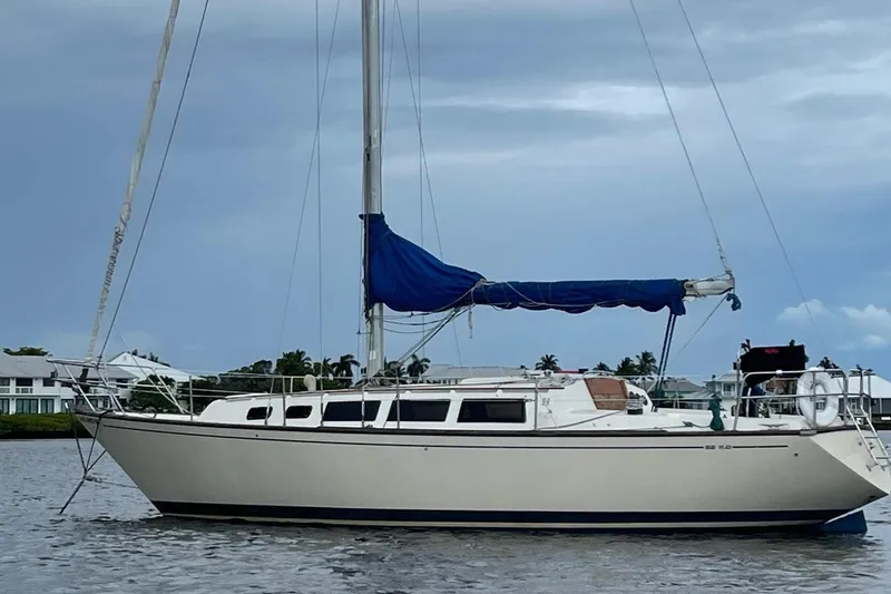 The Image of 1985 S2 11.0A sailboat with blue sail cover on calm water. - 1