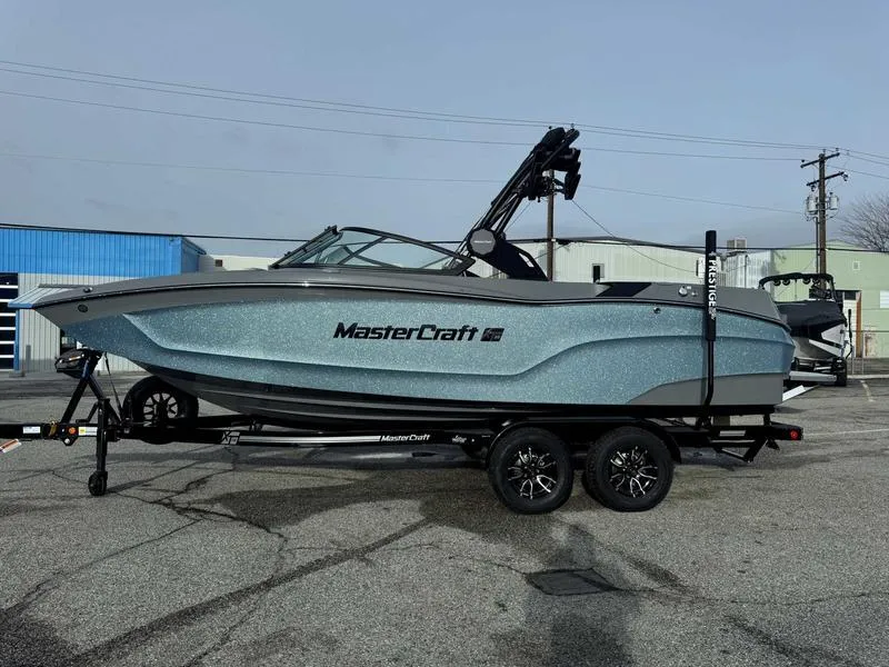 The Image of 2025 MasterCraft XT22 boat on trailer, parked outdoors. - 1