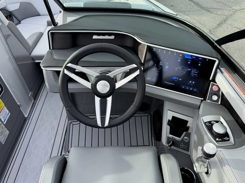 Slide: The Image of 2025 MasterCraft XT22 boat dashboard with modern steering wheel and digital display. - 12
