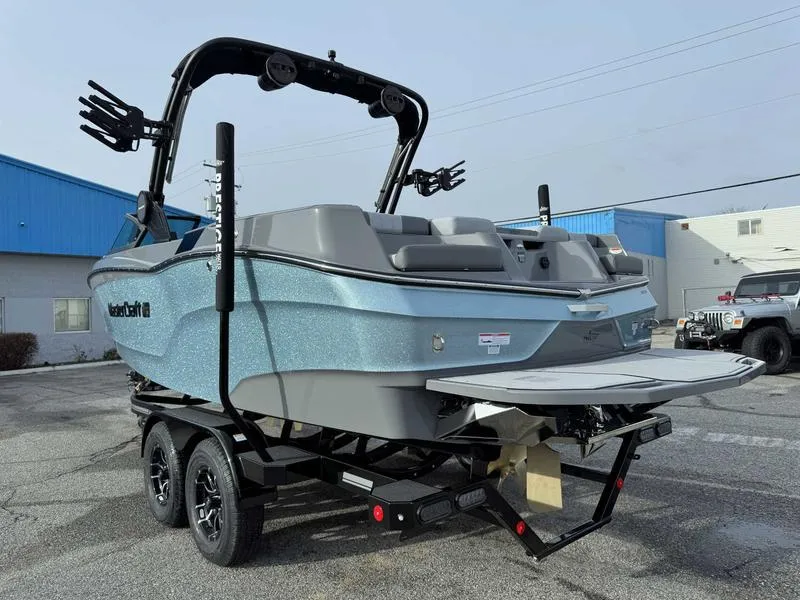 Slide: The Image of 2025 MasterCraft XT22 boat on trailer, parked outdoors. - 6