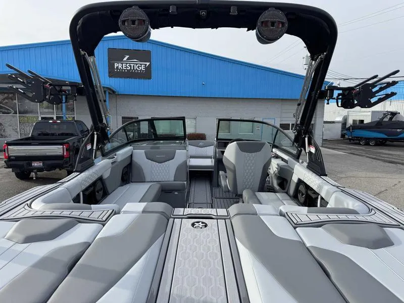 Slide: The Image of 2025 MasterCraft XT22 boat interior with gray seating at Prestige dealership. - 7