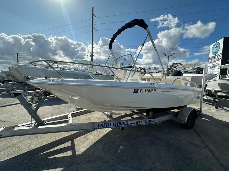 The Image of 2019 Boston Whaler 180 Dauntless boat on trailer under sunny sky. - 1