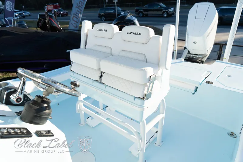 Slide: The Image of 2025 Caymas 28 HB boat interior with dual white cushioned seats and steering console. - 18