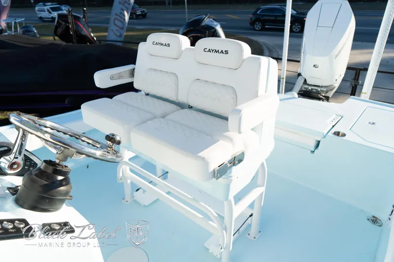 Slide: The Image of 2025 Caymas 28 HB boat interior with dual white cushioned seats and steering wheel. - 19