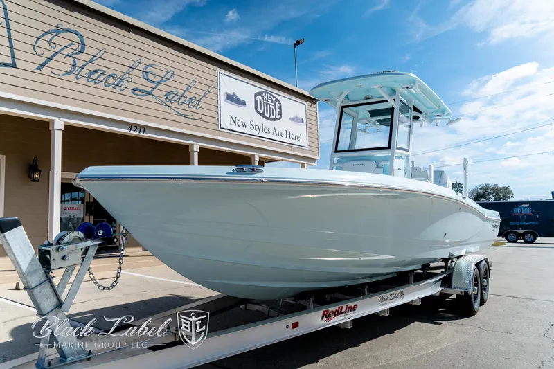 Slide: The Image of 2025 Caymas 28 HB boat on trailer outside Black Label showroom. - 2