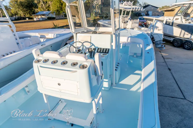 Slide: The Image of 2025 Caymas 28 HB boat, sleek design, spacious deck, modern controls, docked outdoors. - 33