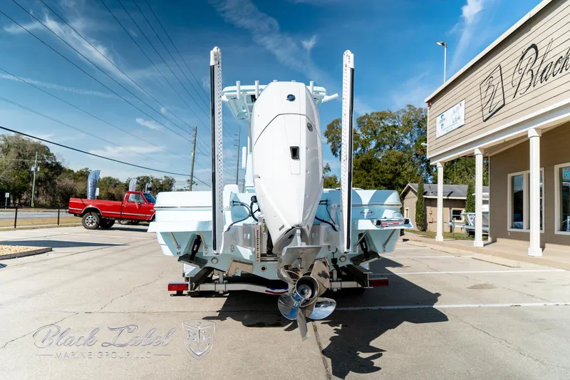 Slide: The Image of 2025 Caymas 28 HB boat parked outside dealership on sunny day. - 5