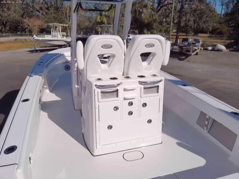 Slide: The Image of 2025 Sportsman Masters 267OE Bay Boat interior with dual seats and storage console. - 4