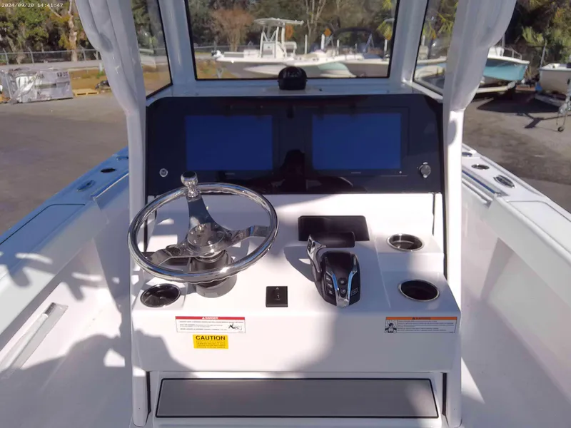 Slide: The Image of 2025 Sportsman Masters 267OE Bay Boat helm with steering wheel and dual screens. - 5
