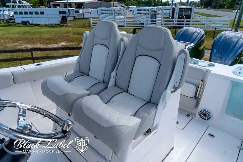 Slide: The Image of 2023 Sea Fox 288 Commander boat seats with steering wheel, outdoor setting. - 23