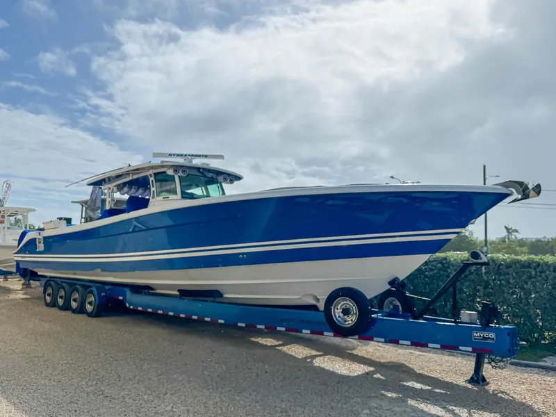 Slide: The Image of 2018 HCB 53 Suenos RXV boat on trailer, blue and white design. - 1