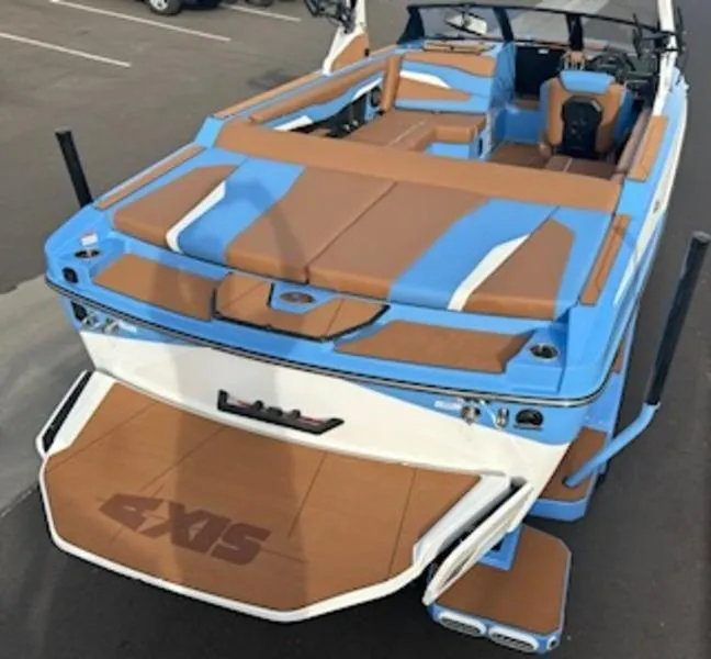 Slide: The Image of 2025 Axis T220 boat with blue and brown upholstery, parked on pavement. - 10