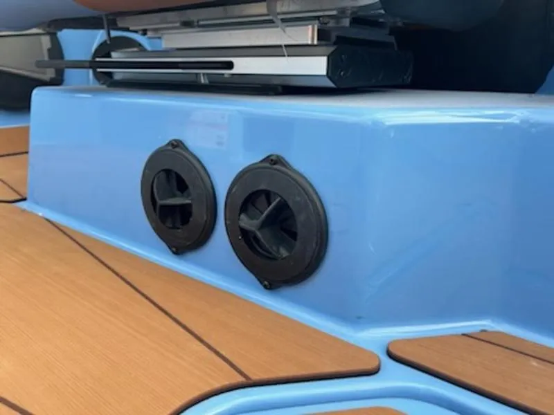 Slide: The Image of 2025 Axis T220 boat interior with blue and wood accents, featuring dual cup holders. - 19