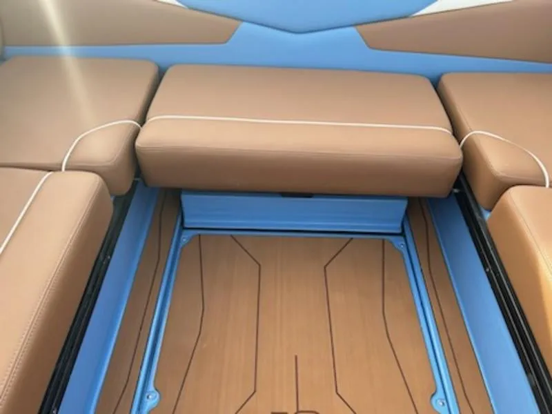 Slide: The Image of 2025 Axis T220 boat interior with brown seating and blue accents. - 21