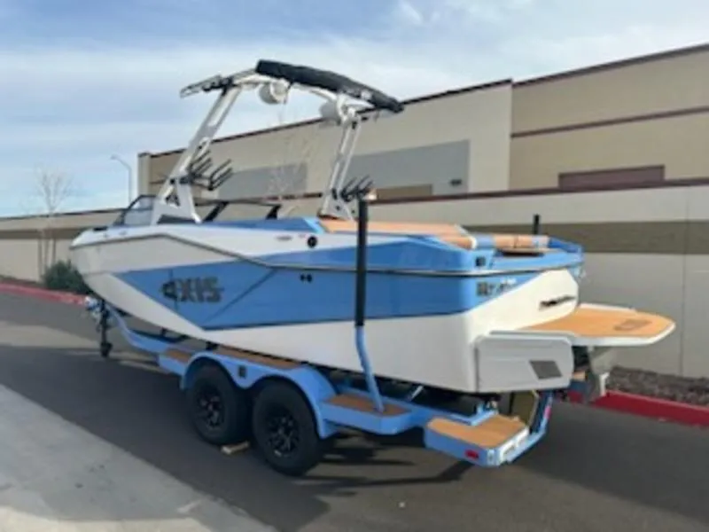 Slide: The Image of 2025 Axis T220 boat on trailer, blue and white design, parked outdoors. - 4