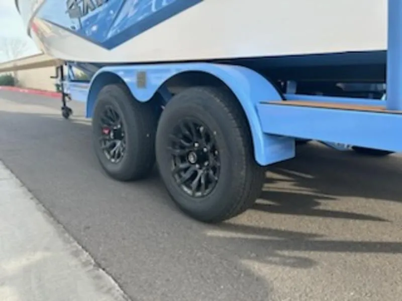 Slide: The Image of 2025 Axis T220 boat trailer with black wheels on a paved road. - 7