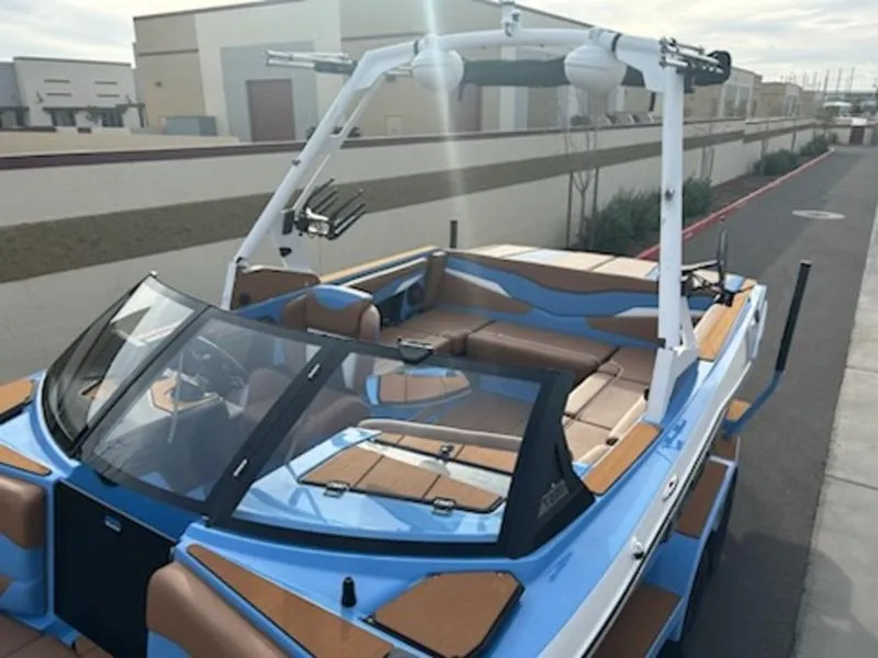 Slide: The Image of 2025 Axis T220 boat with blue and brown interior, parked outdoors. - 8