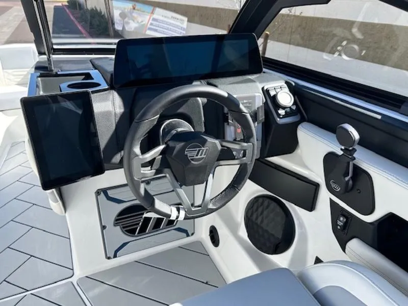 Slide: The Image of 2025 Malibu 26 LSV boat cockpit with modern steering and digital displays. - 14