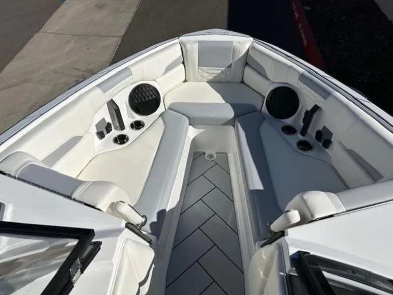 Slide: The Image of 2025 Malibu 26 LSV boat interior with white seating and cup holders. - 17