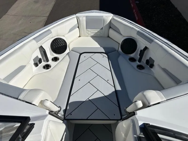 Slide: The Image of 2025 Malibu 26 LSV boat interior with white seating and built-in speakers. - 18