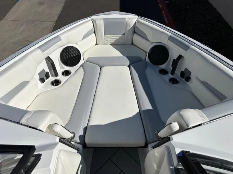 Slide: The Image of 2025 Malibu 26 LSV boat interior with white seating and cup holders. - 19