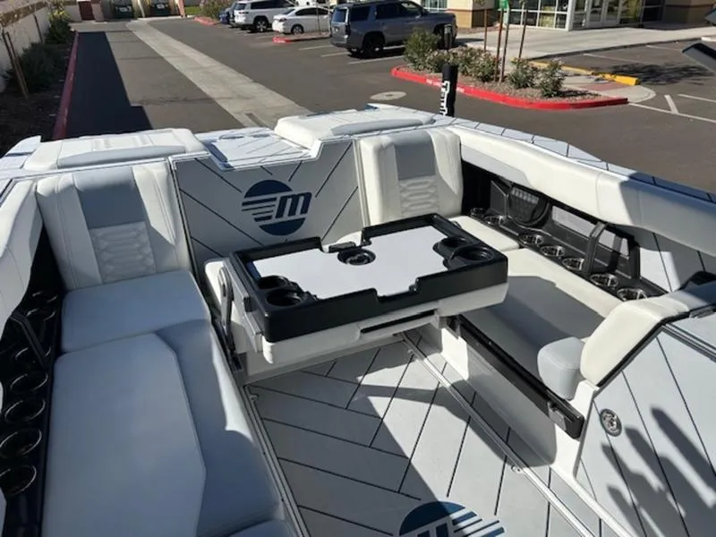 Slide: The Image of 2025 Malibu 26 LSV boat interior with sleek seating and table setup. - 23