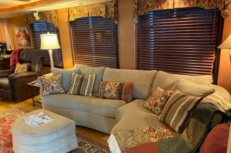 Slide: The Image of Cozy living room with sectional sofa, patterned pillows, and warm lighting in a 2004 Sumerset houseboat. - 30