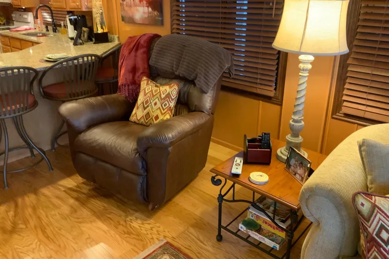 Slide: The Image of Cozy living area with leather recliner, decorative pillows, and a side table in a Sumerset 18 x 87 houseboat. - 31