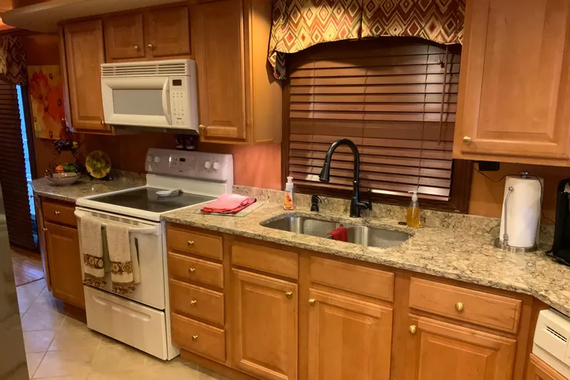 Slide: The Image of Modern kitchen in 2004 Sumerset 18 x 87 houseboat with wooden cabinets and granite countertops. - 40