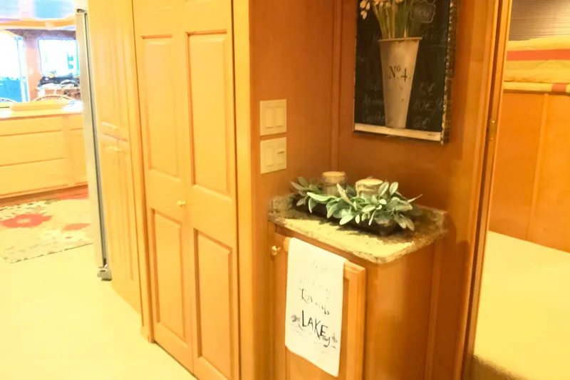 Slide: The Image of Interior of 2004 Sumerset 18 x 87 houseboat with wooden cabinetry and decorative plants. - 42