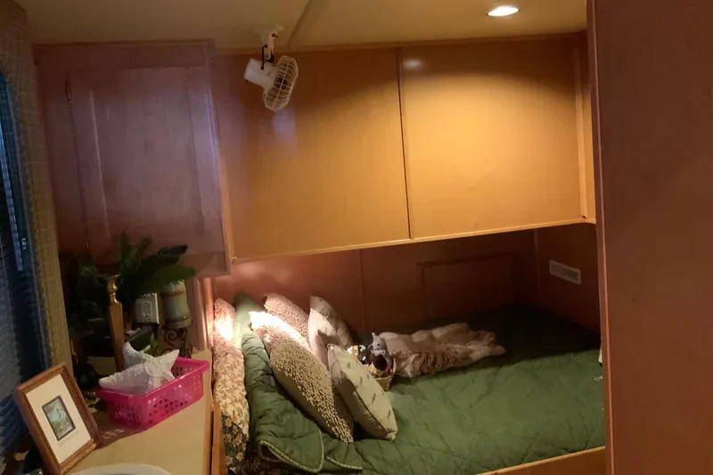 Slide: The Image of Cozy bedroom interior in 2004 Sumerset 18 x 87 houseboat with green bedding and wooden cabinets. - 45