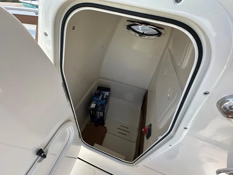 Slide: The Image of 2025 Pioneer 222 Sportfish storage compartment with porthole and supplies. - 10